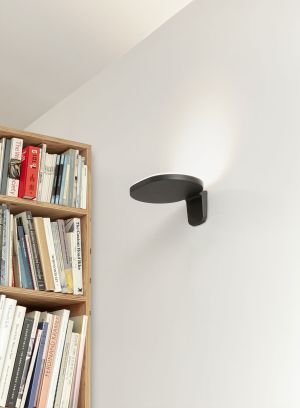 Oplight W1 i sort på vegg i stue. Foto