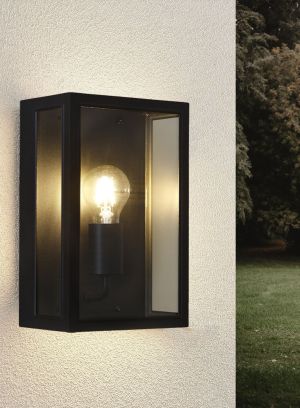 Roma vegglampe i sort fra Høvik lys med en lyspære plassert inne i en boks. Montert på veggen ute, lys på