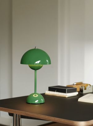 Flowerpot VP9 oppladbar bordlampe H30 fra Tradition i grønn. Plassert på et sort bord. Lys på