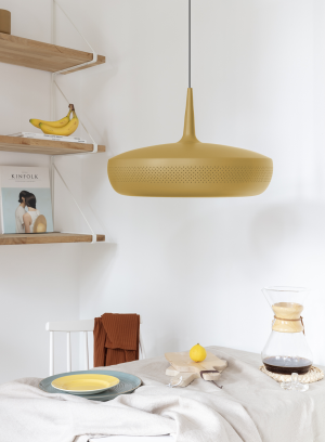 Clava Dine taklampe fra Umage i gul. henger over et spisebord med duk og servise. lys av