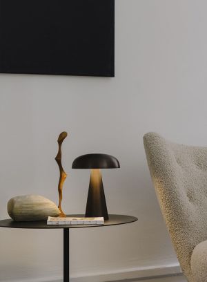Como S53 oppladbar bordlampe i bronse på et sidebord i en stue