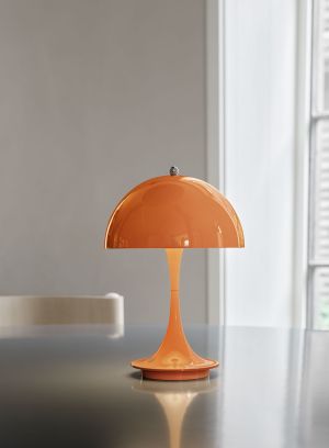 Panthella 160 oppladbar bordlampe oransje på bord. Foto