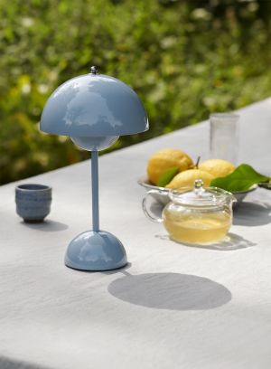Flowerpot VP9 oppladbar bordlampe H30 fra Tradition i lyseblå. Plassert på et bord ute ved siden av frukt. Lys av