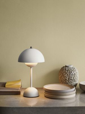 Flowerpot VP9 oppladbar bordlampe i matt lys grå på en skjenk