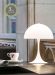 Panthella mini bordlampe fra Louis Poulsen i hvit. Plassert på et bord, lys på