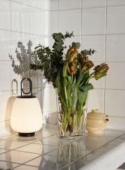 Lucca SC51 oppladbar bordlampe ved en blomstervase