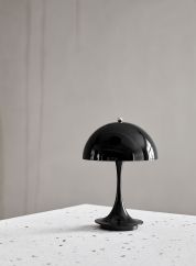 Panthella 160 oppladbar bordlampe i sort på et bord