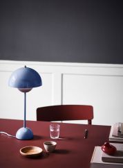 Flowerpot VP3 bordlampe H50 fra Tradition i blå. Plassert på et rødt spisebord, lys på