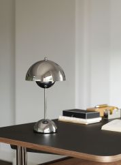 Flowerpot VP9 oppladbar bordlampe H30 fra Tradition i sølvfarge. Plassert oppå et sort bord. lys av