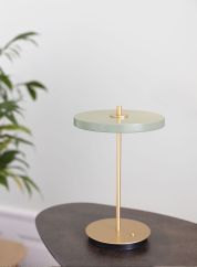 Asteria move oppladbar bordlampe på et lite bord. Foto