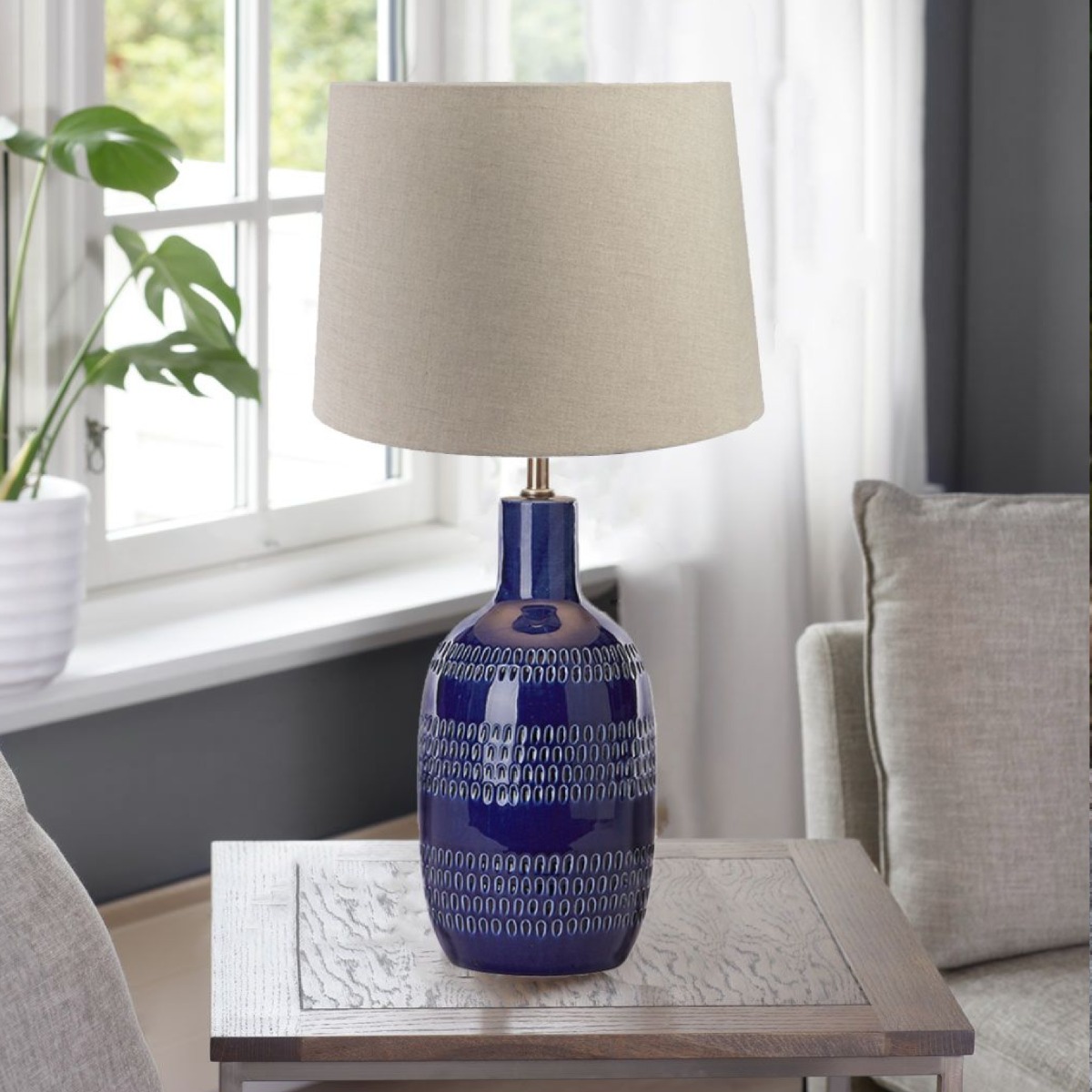 Zanta bordlampe i kobolt blå fra MS Belysning stående på et sidebord