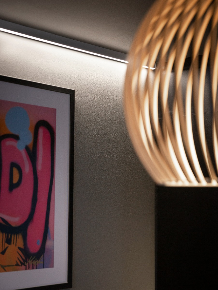 LED-profil i skråtak gir utvidet romfølelse og fin lyseffekt - her ser du det i en stue hos en kunde