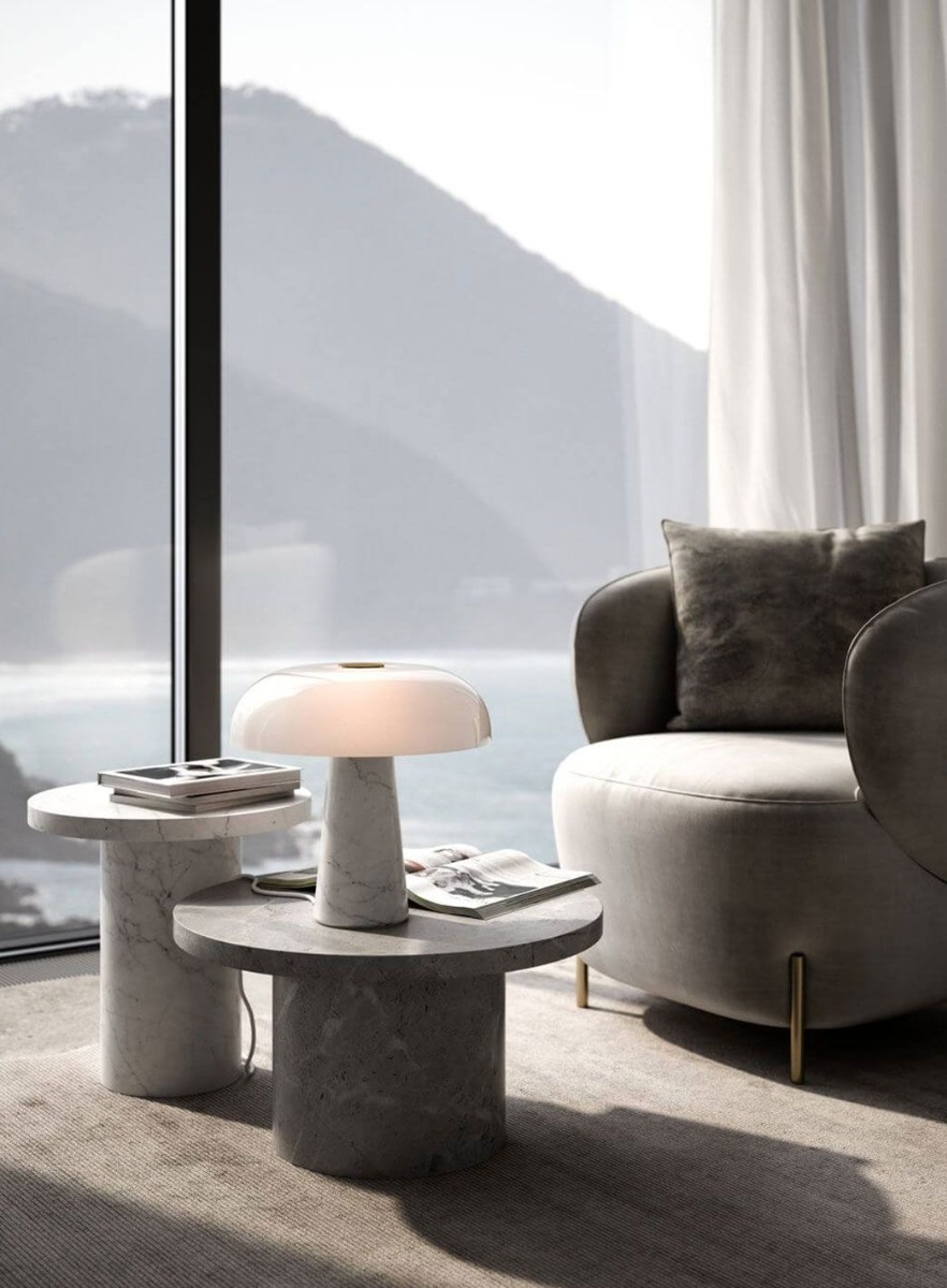 Glossy bordlampe i marmor/glass stående på et sidebord i en stue.